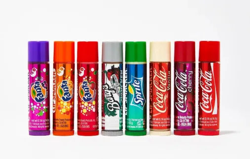 Eight Lip Smacker lip balms in soda flavors including Fanta, Barq's Root Beer, Sprite, Coca-Cola Vanilla, Cherry, and Classic.